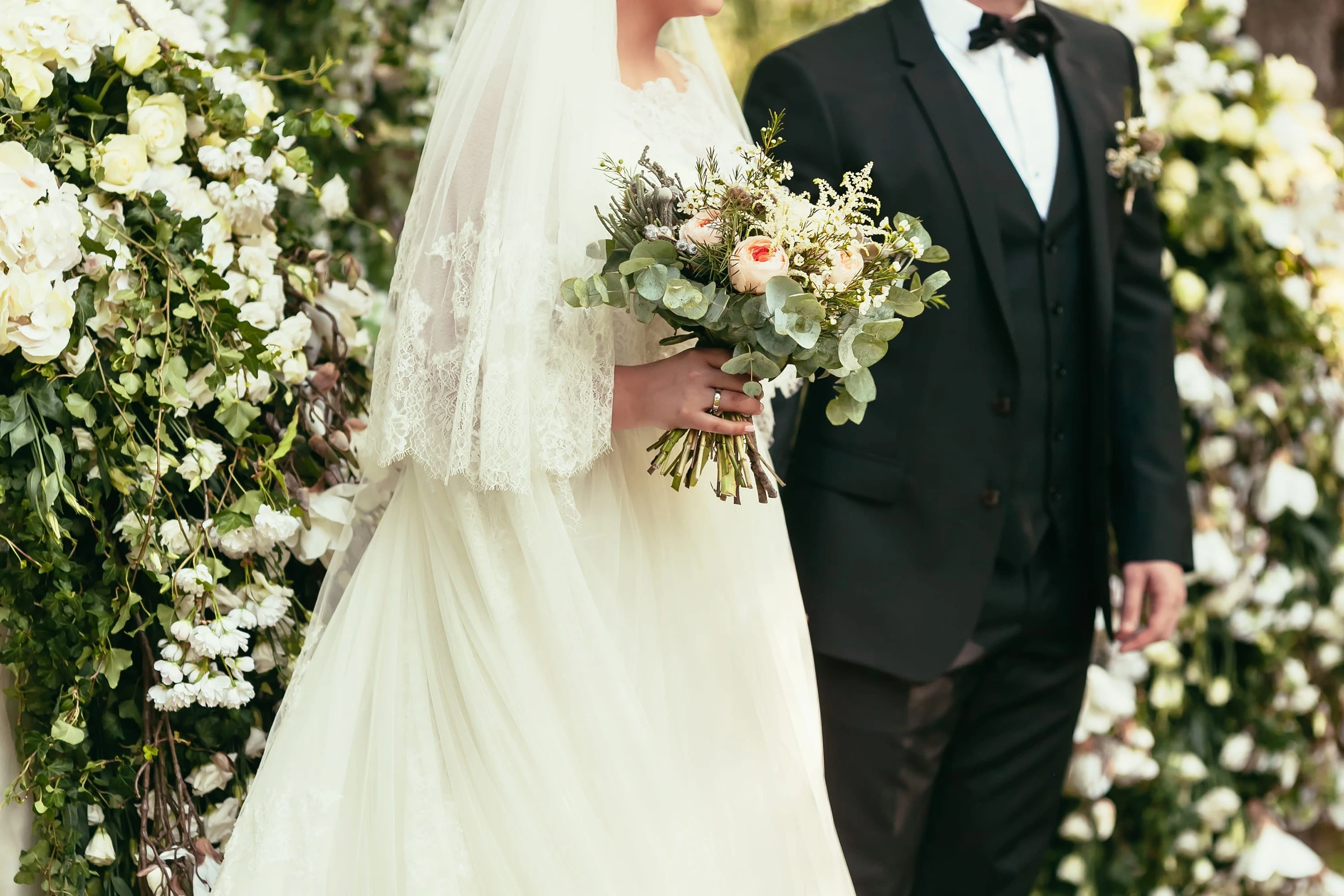51919452_m groom in black suit and bride in white wedding dress with rustic bouquet on wedding ceremony outdoor<br />s<br />stakhov<br />