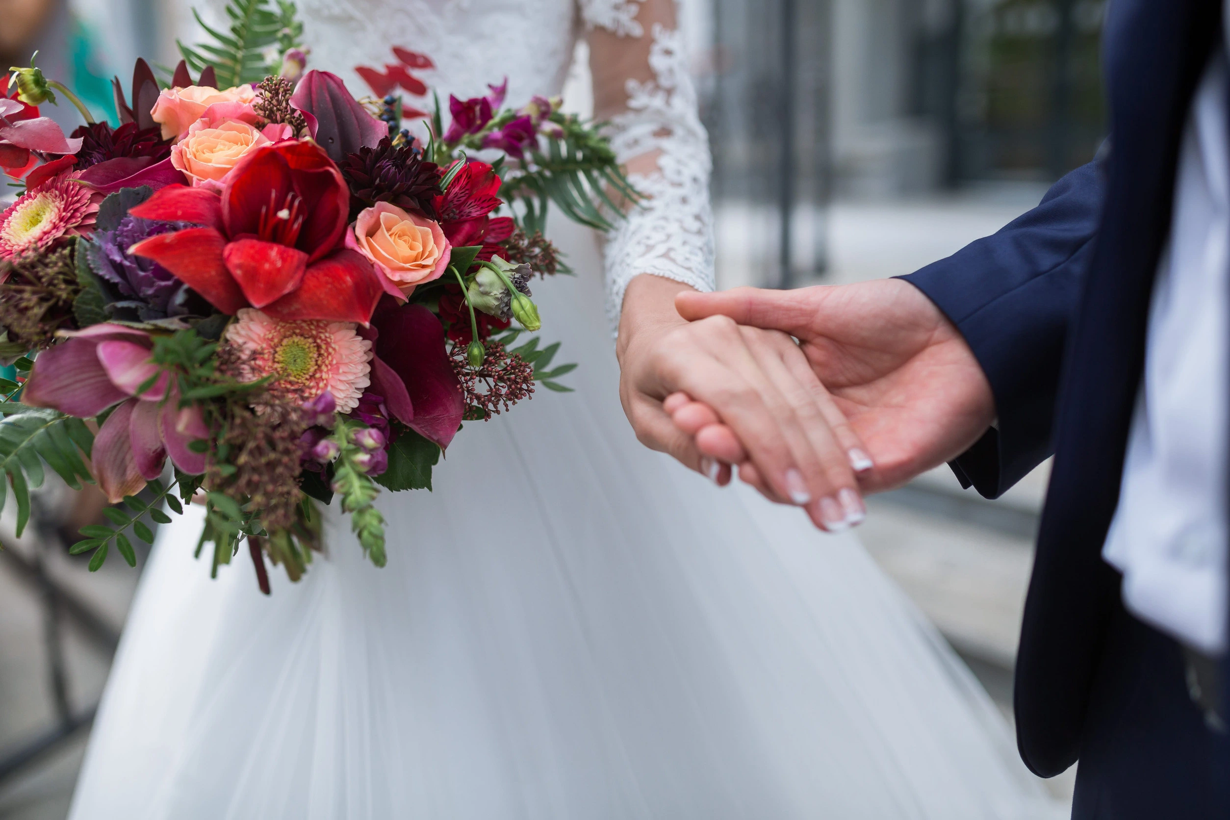 66541601_m Beautiful Weding bouquet of different flowers in the hands of the bride in a white wedding dress. Bride holding grooms hand. Wedding ceremony concept