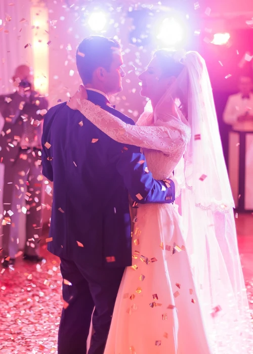 Brides wedding party in the elegant restaurant with wonderful light and atmosphere. Beautiful married couple dancing.